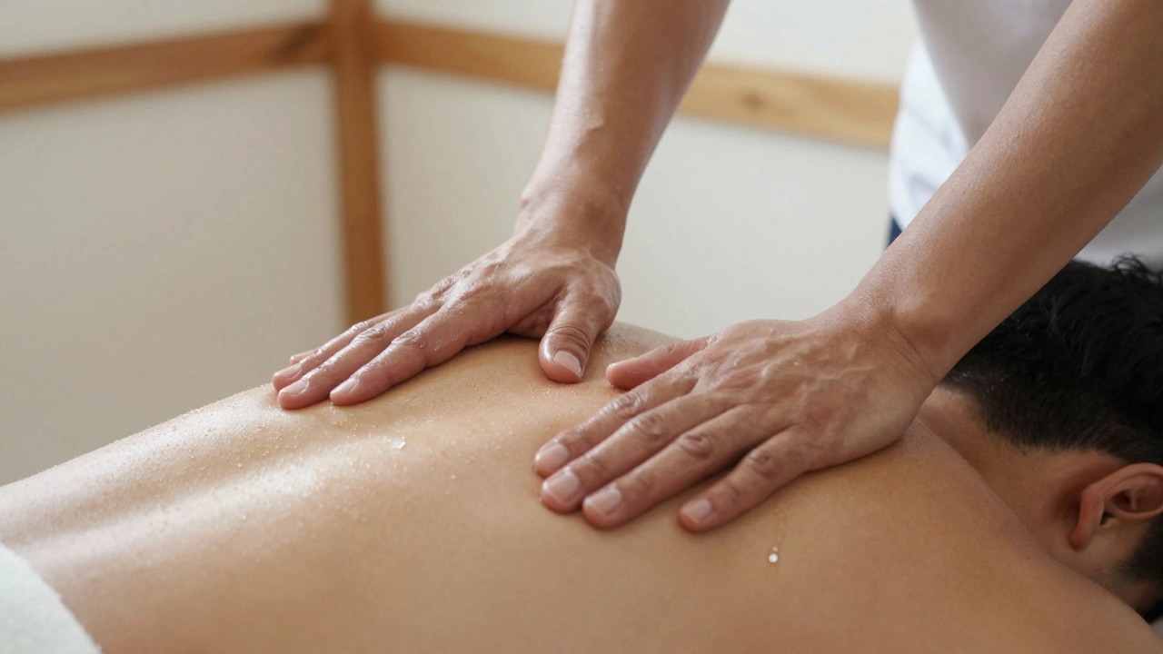 Mains d’un masseur travaillant sur les épaules d’un homme, avec de l’huile qui brille doucement.