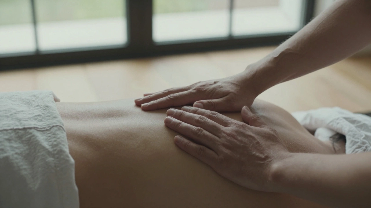 Deux mains en contact doux, massant les épaules dans une lumière naturelle.